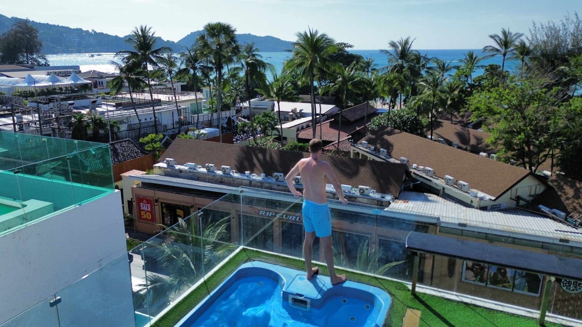 Remco on a rooftop overlooking a tropical beach